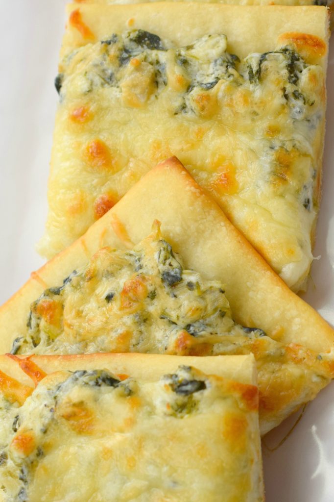 Creamy Spinach and Artichoke Pizza is a definite family favorite in our house. A simple dinner or party food, this is one deliciously cheesy meal.