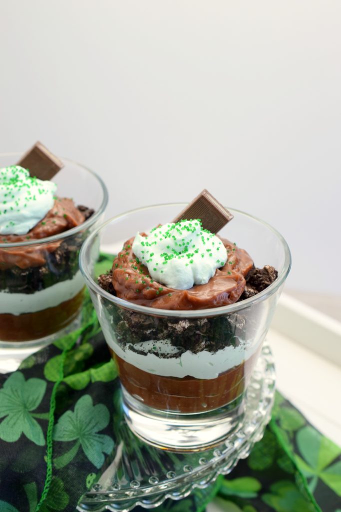 two individual glasses filled with dessert alongside St. Patrick's Day shamrock decor